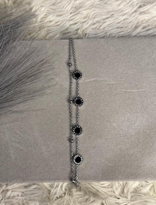 Stainless steel adjustable bracelet with black crystal circle charms.